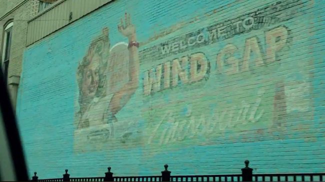 In the series, you see the postcard-themed mural with the words “Welcome to Wind Gap, Missouri.” Shots of this mural are visible throughout the series. It was aged on the show to coincide with the history of the town.