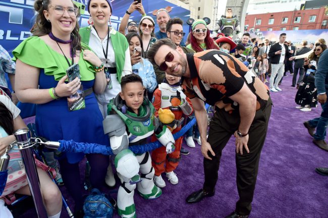 Chris Evans, who takes over the role of Buzz Lightyear from Tim Allen in the film, greets the fans who turned out for the premiere and poses with a young fan dressed up as Buzz Lightyear.