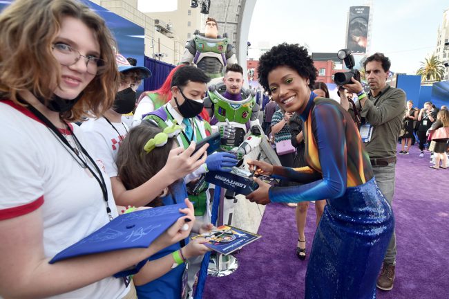 Keke Palmer, who plays Izzy Hawthorne, is all smiles as she signs autographs for fans on the carpet. 