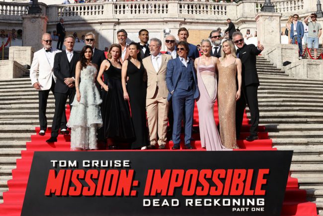 The cast poses with the Mission: Impossible – Dead Reckoning Part One sign. Photo by:  Stefania M. D’Alessandro/Getty Images for Paramount Pictures